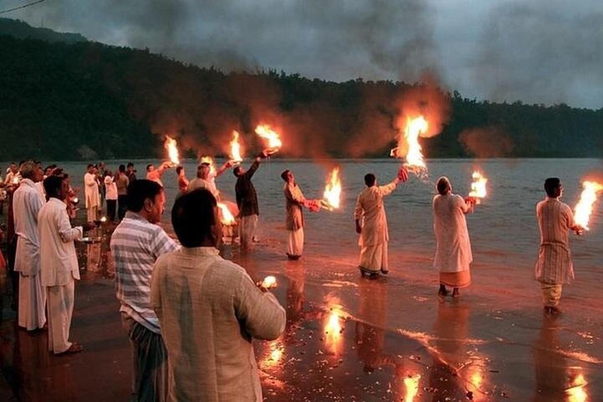 un grup de persones dempeus a l'aigua amb torxes