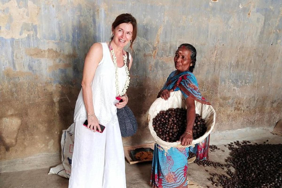 two women standing next to a basket of grapes
