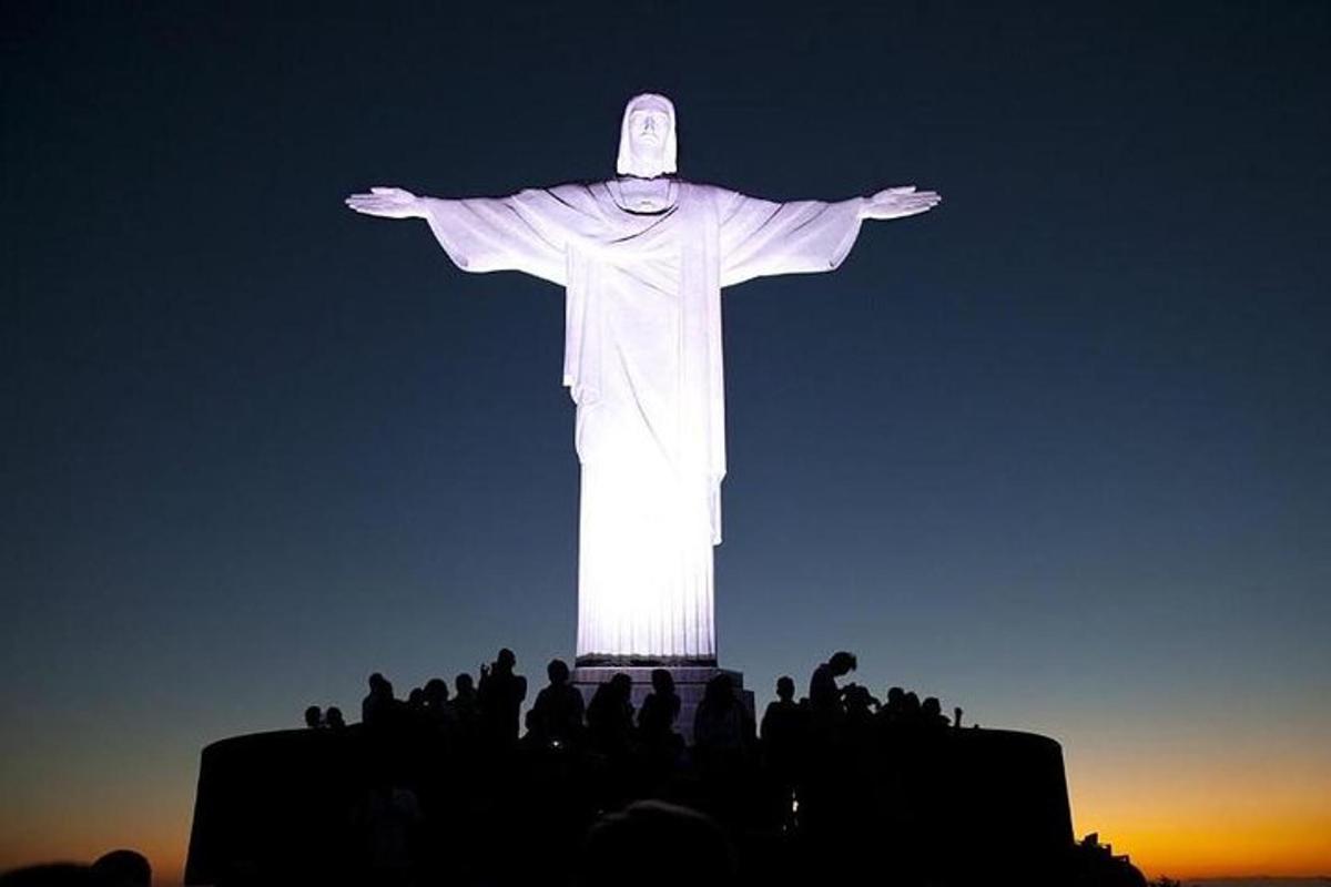 a group of people standing in front of the christ the redeemer statue