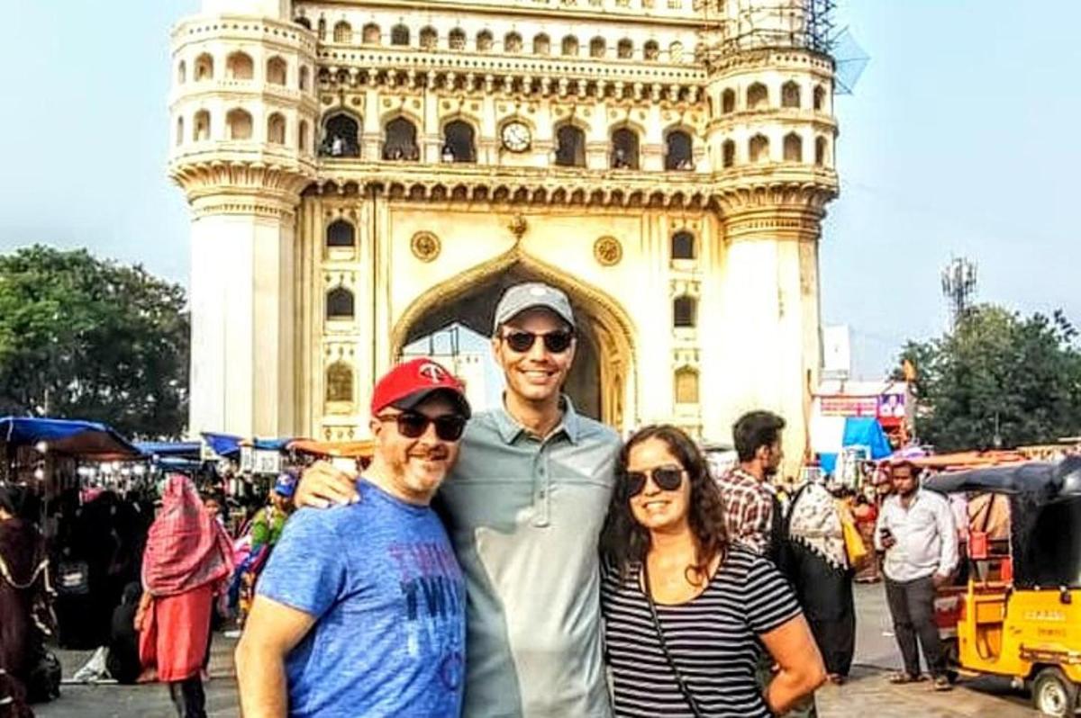 a group of three people standing in front of a tower