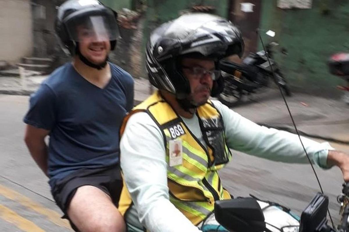dva muži jedoucí na motorce s přilbami na hlavách