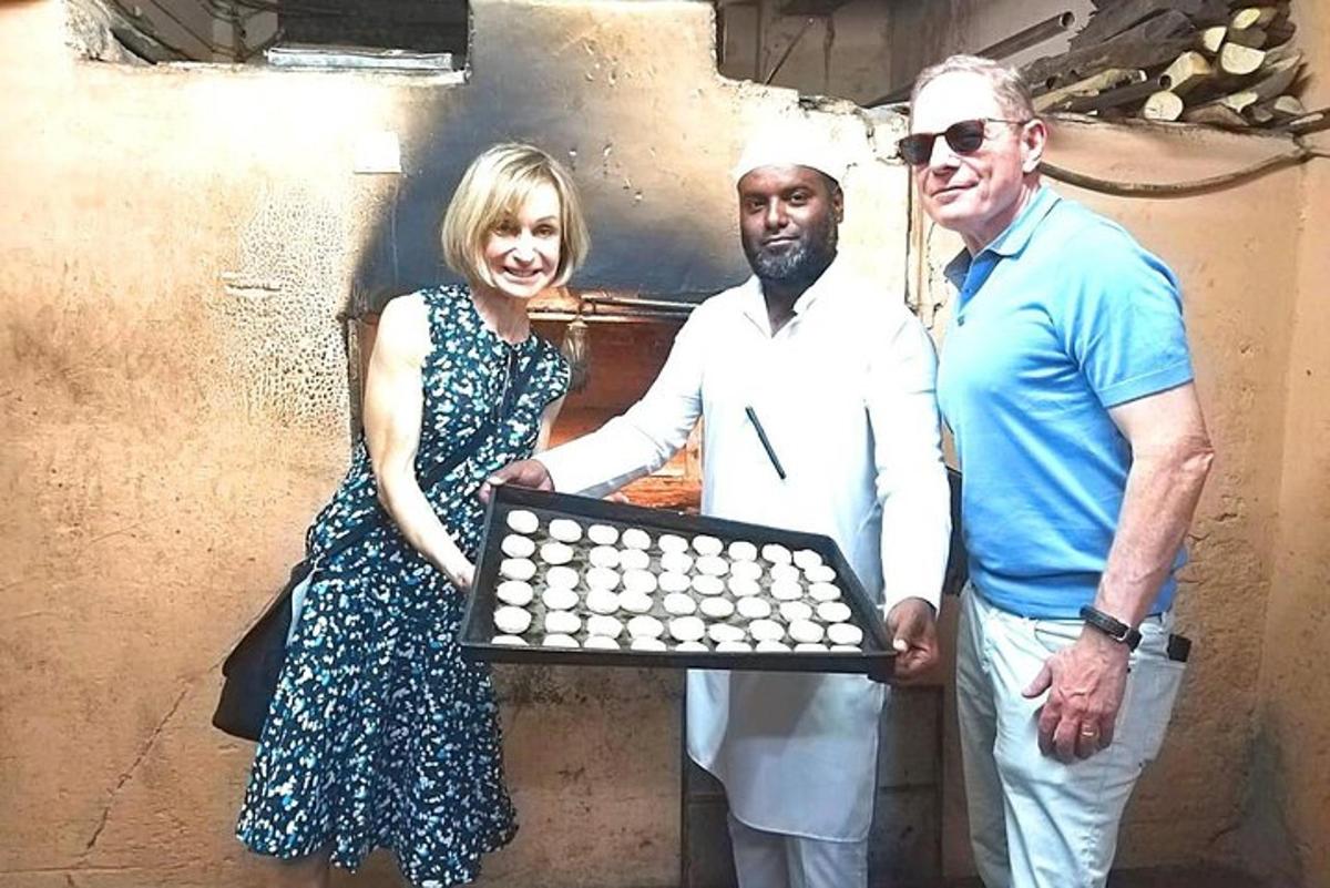 a woman and two men holding a tray of dominoes