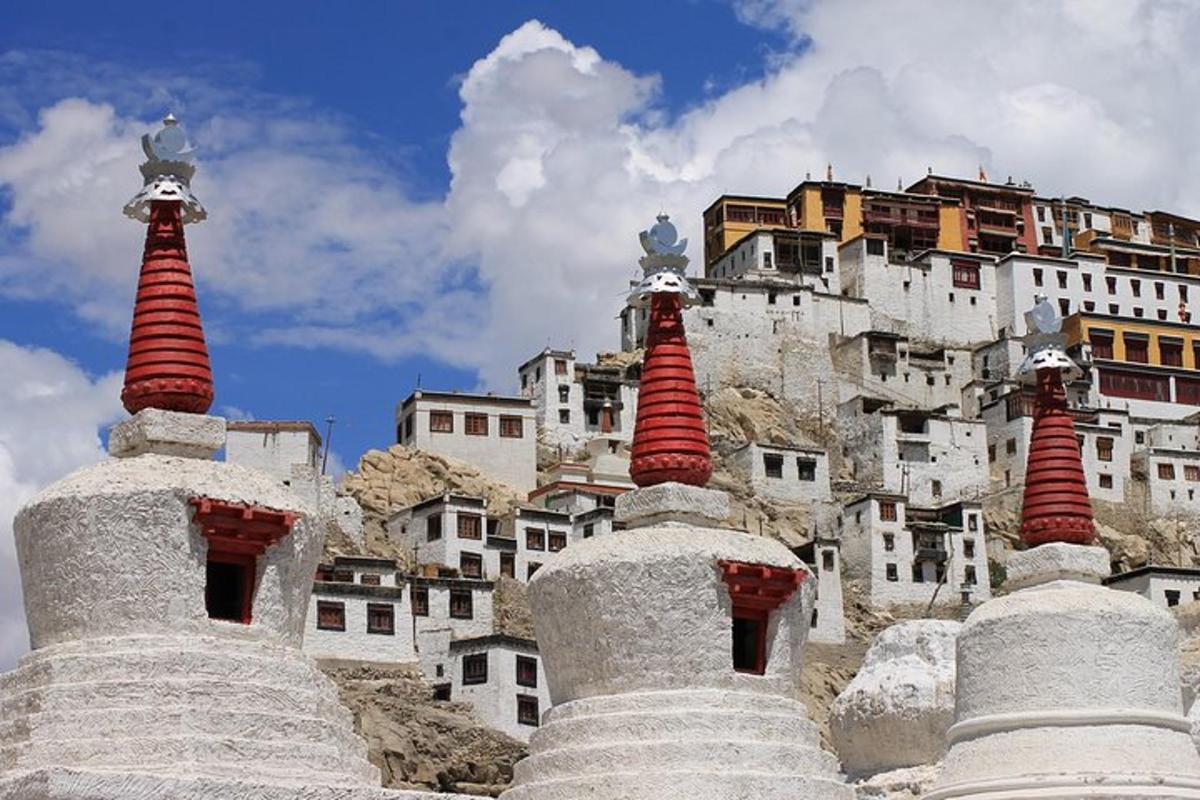 a group of stone structures with a building in the background