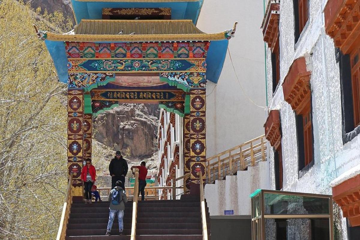 a gate to a temple with people walking up the stairs