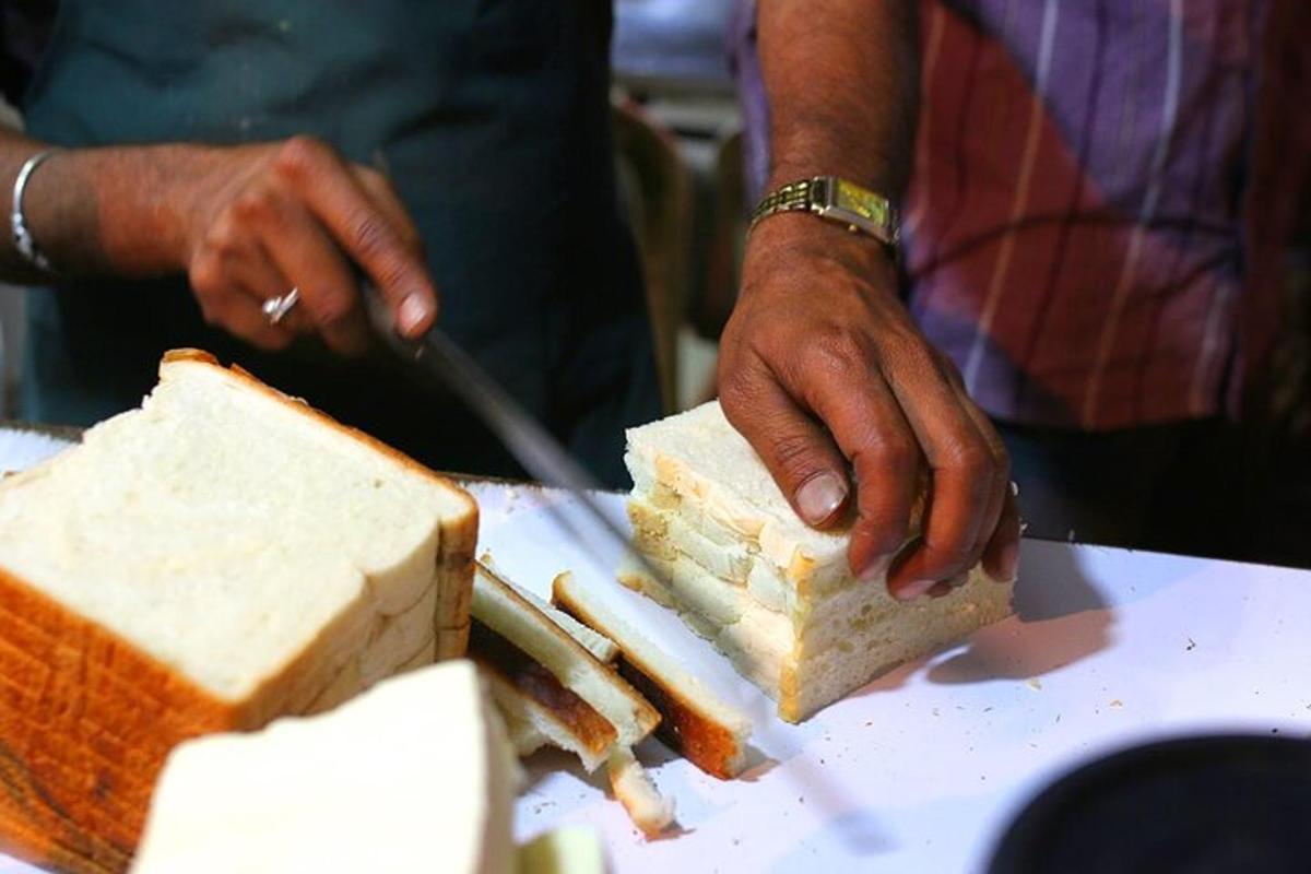 a person cutting a piece of white bread on a plate