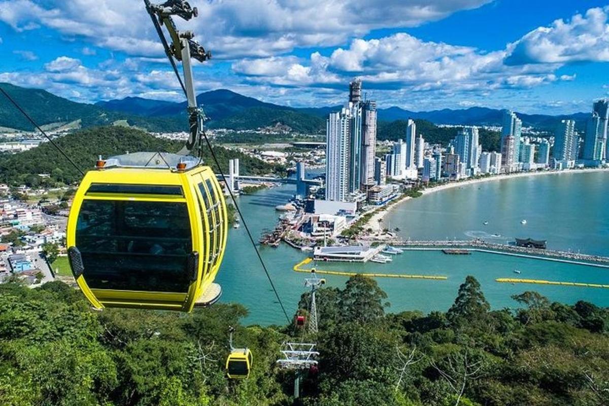 a yellow gondola is flying over a city