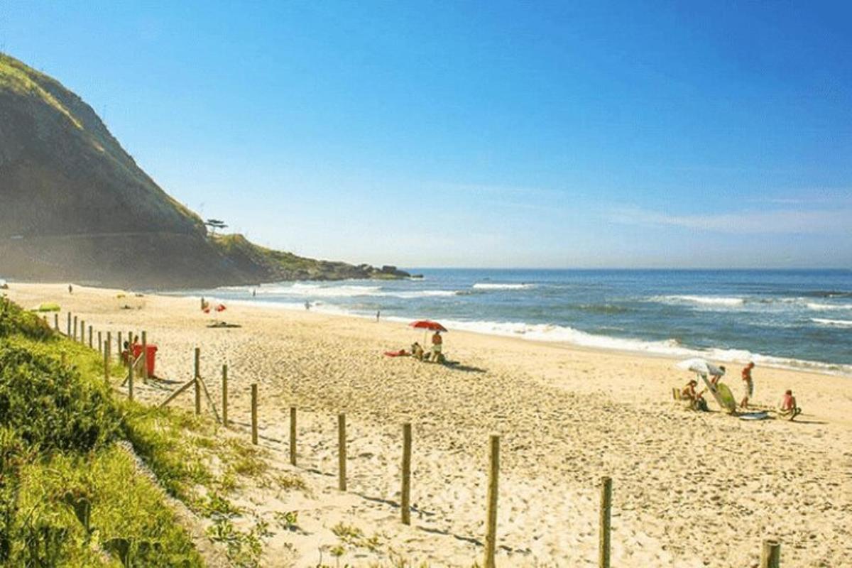plaža z ljudmi na pesku in ocean