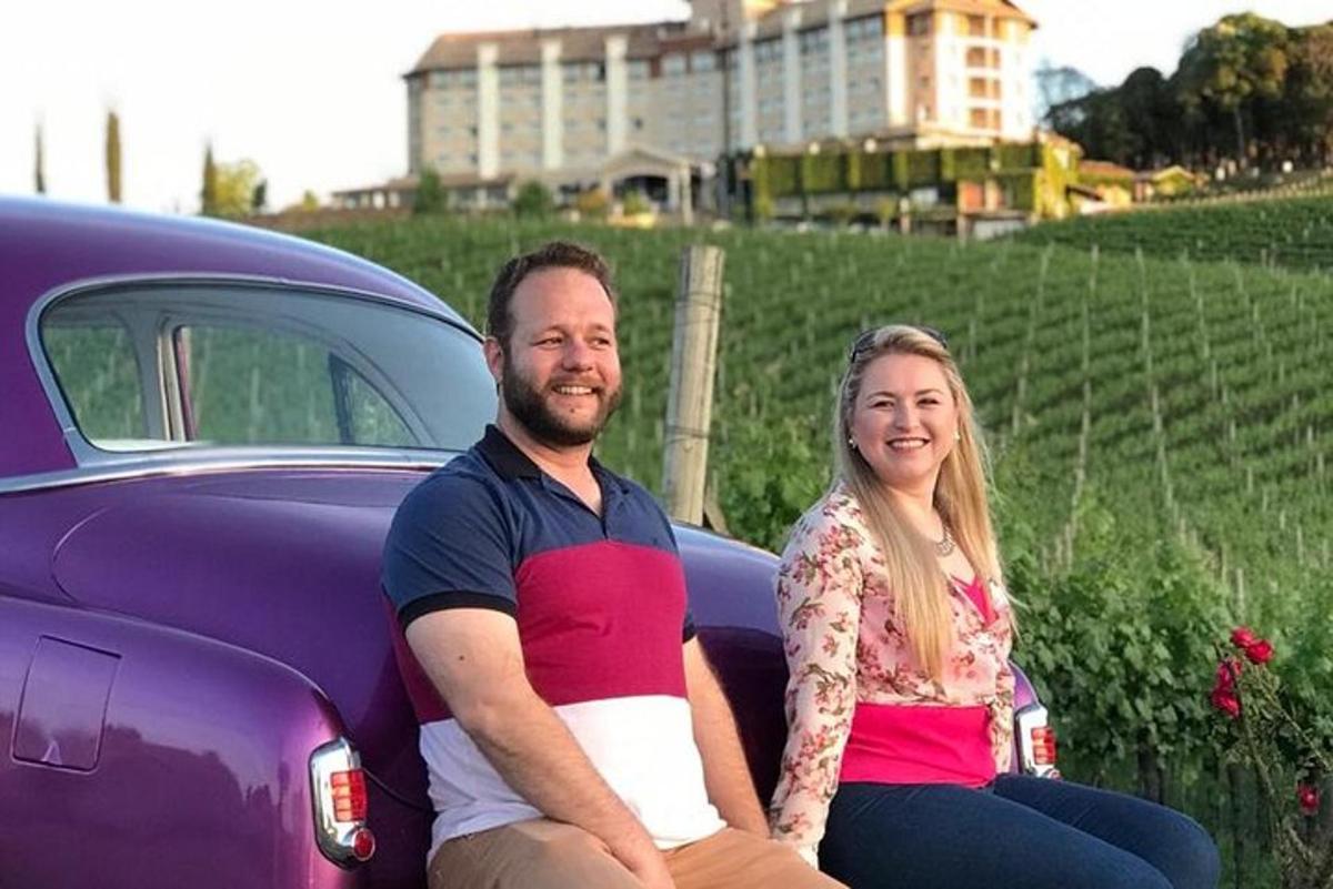 a man and woman sitting on the hood of a purple car