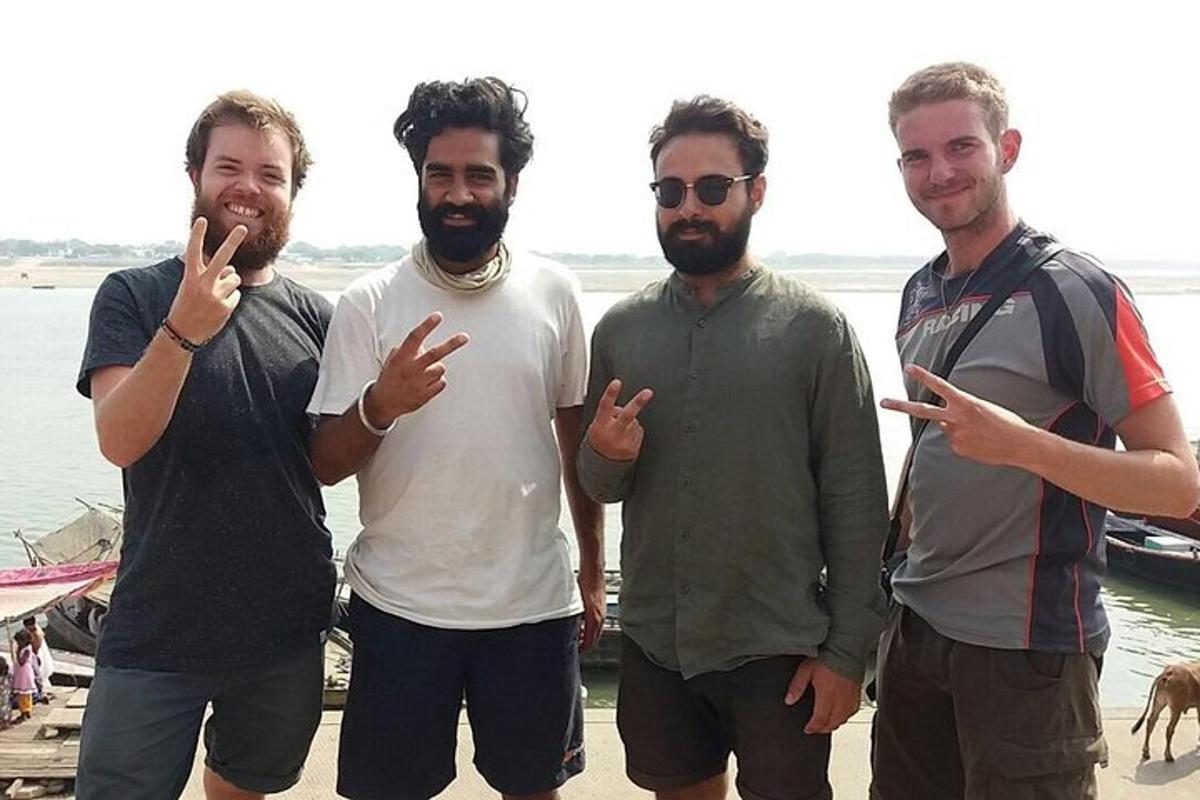 un gruppo di quattro uomini in piedi accanto all'acqua