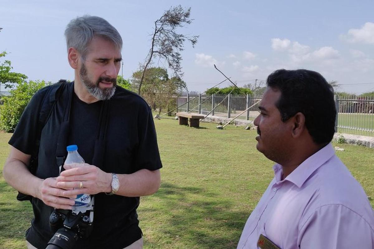 a man holding a camera and a man with a bottle