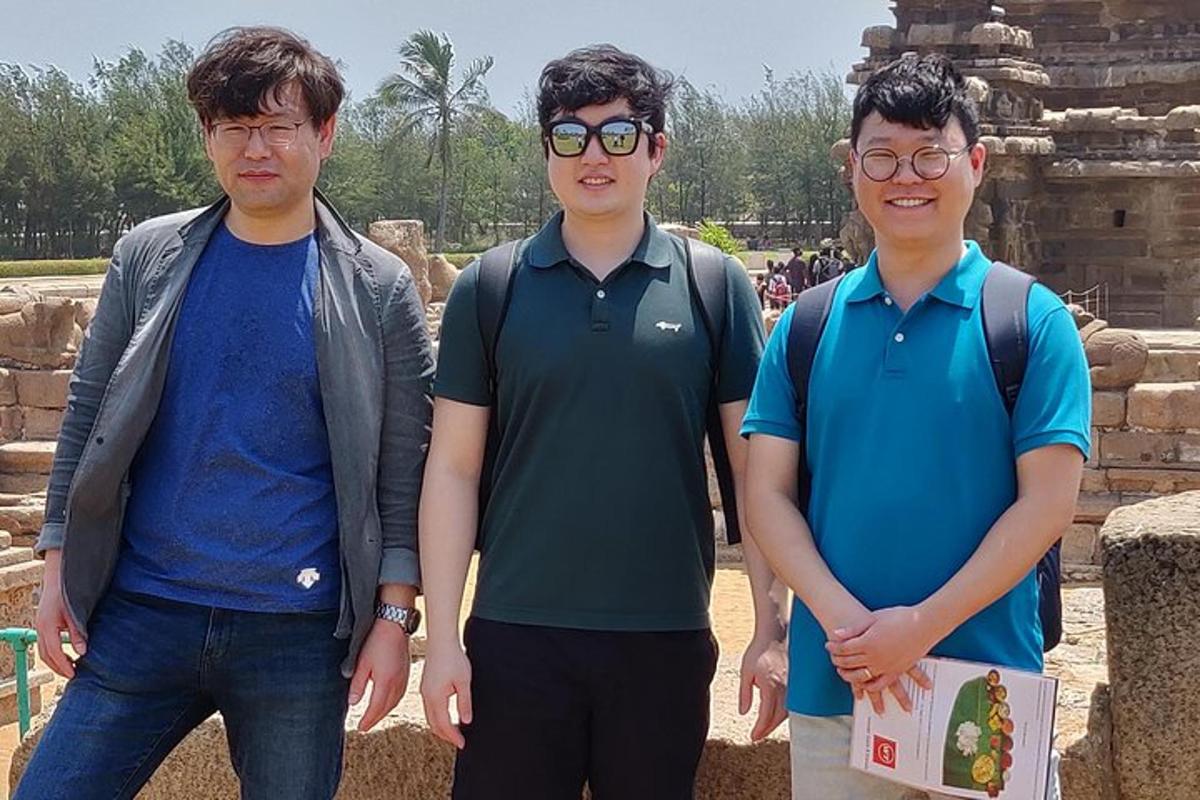 three young men standing in front of a temple