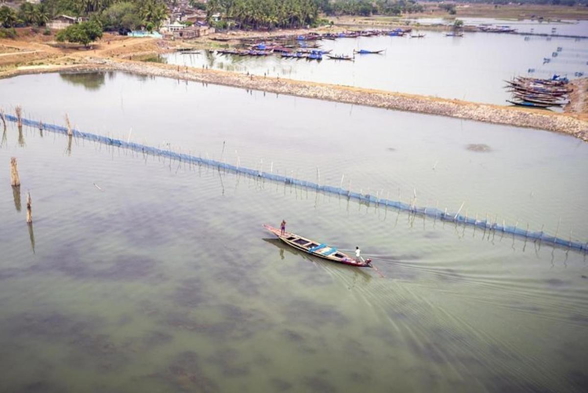 a small boat in the water next to a pier