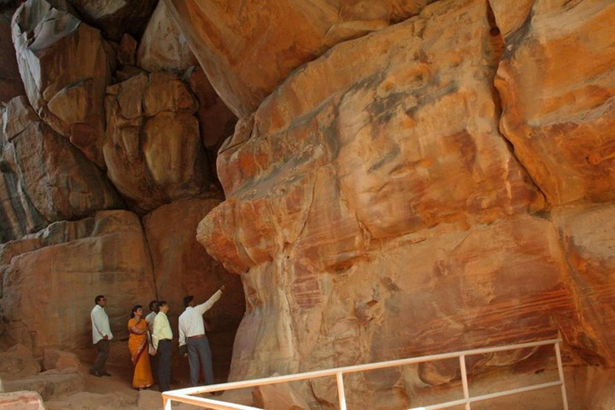 a group of people standing next to a rock wall