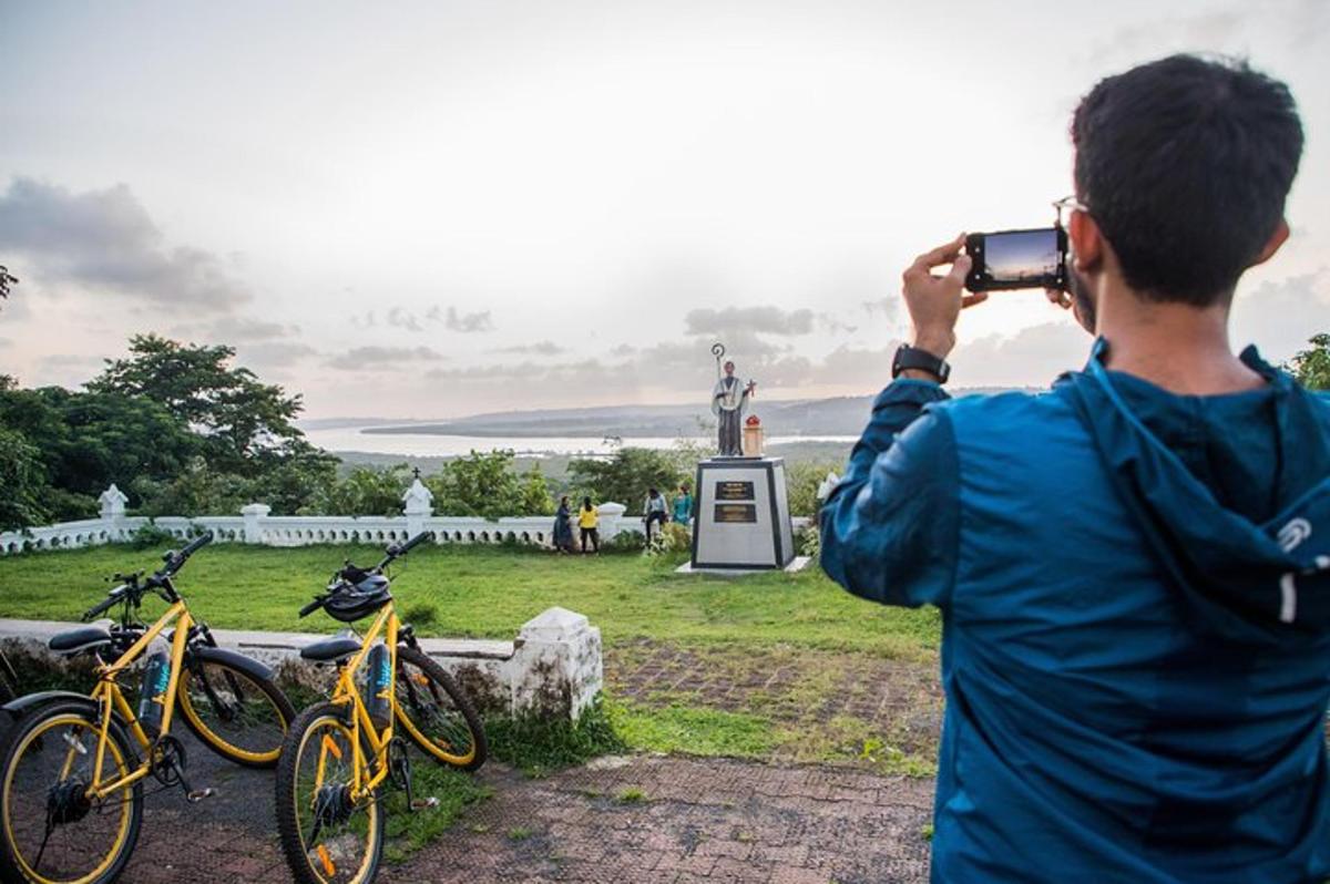 a man taking a picture of bikes in front of a statue