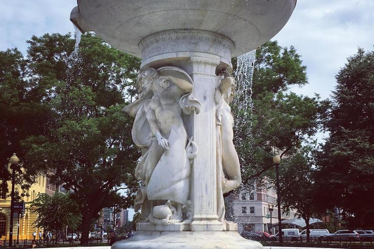 una estatua en un parque con una fuente de agua
