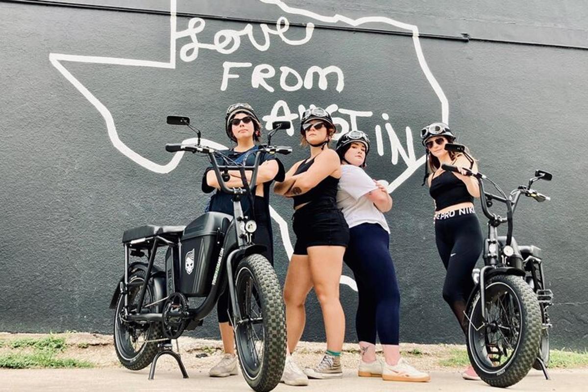 a group of women standing next to a motorcycle