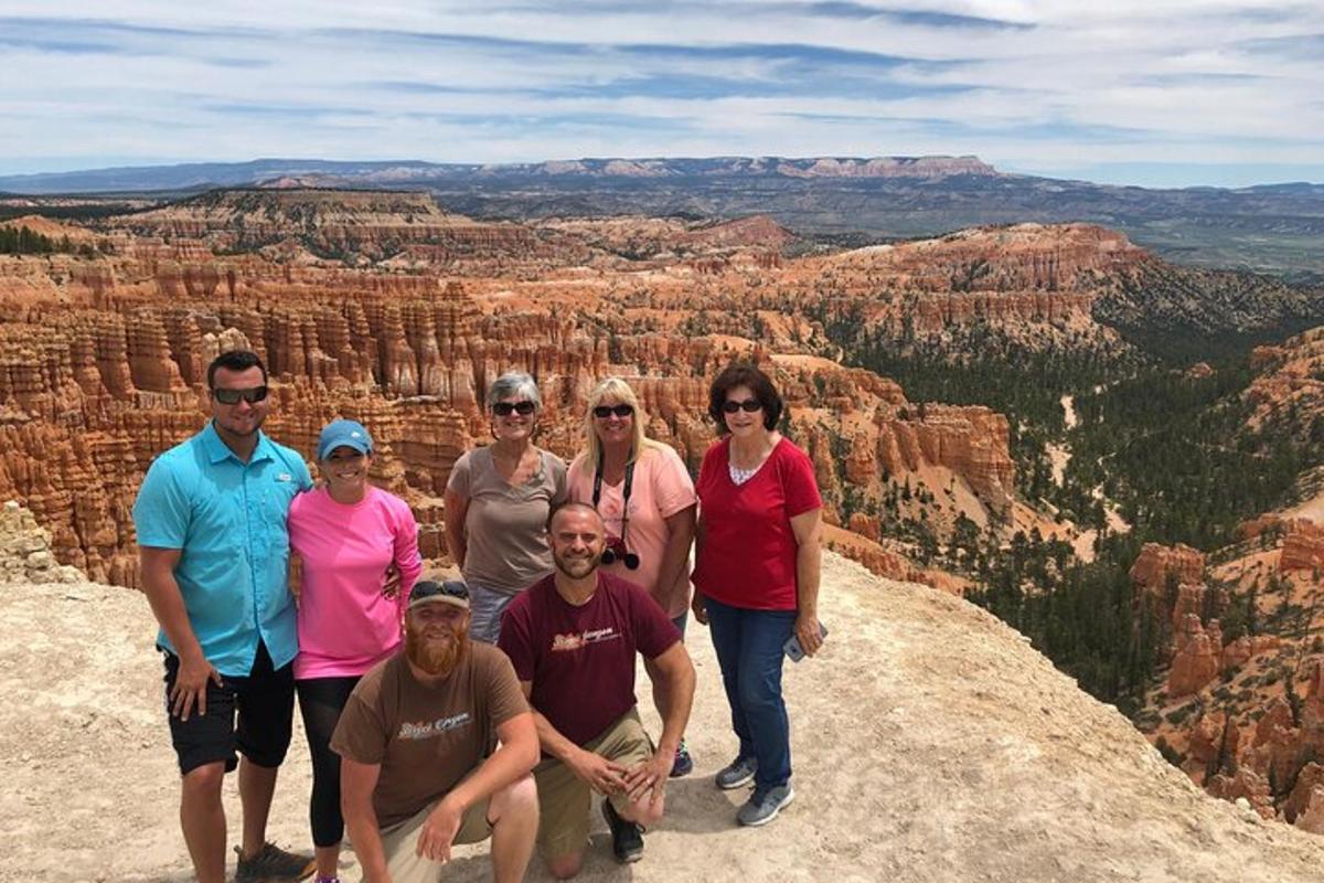 a group of people posing for a picture at the grand canyon