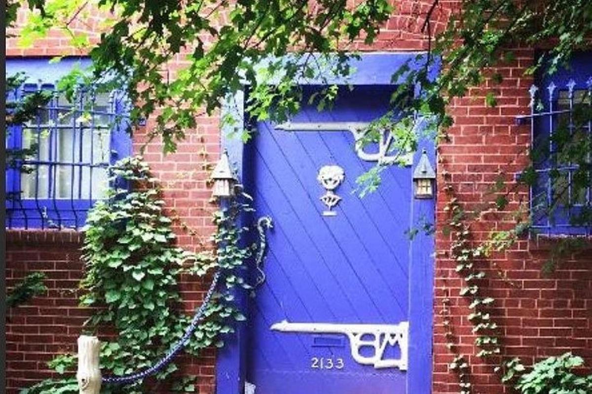 una puerta azul en el costado de un edificio de ladrillo