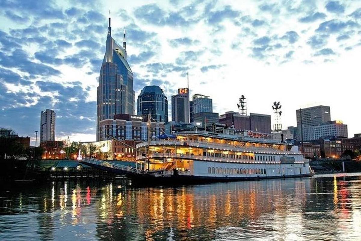 a cruise ship docked in a river with a city