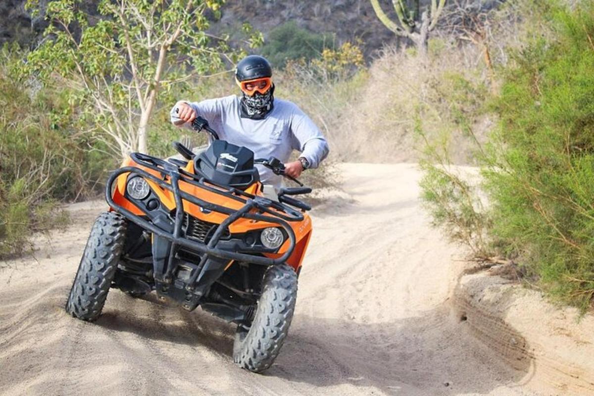 ein Mann, der mit einem Dirtbike eine unbefestigte Straße entlang fährt