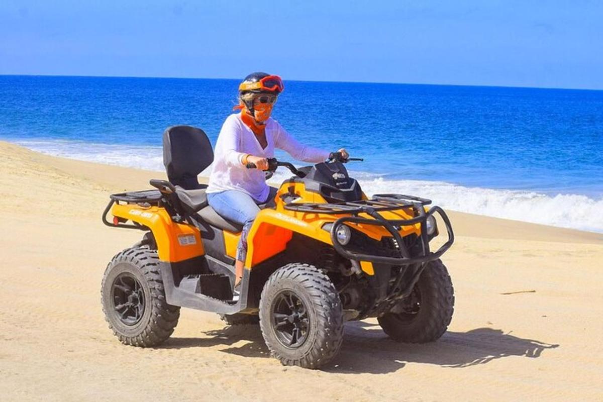 eine Person, die mit einem Quad am Strand fährt