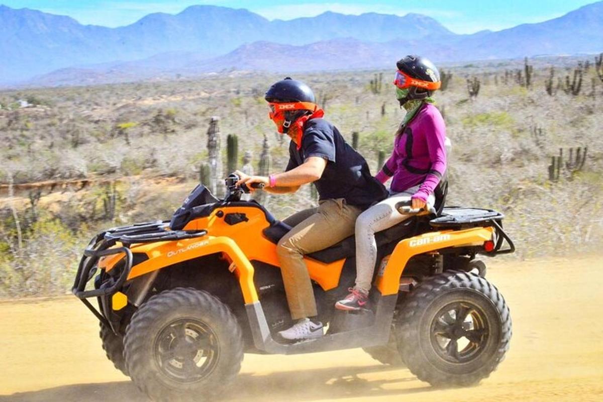 ein Mann und eine Frau fahren auf einem Quad in der Wüste