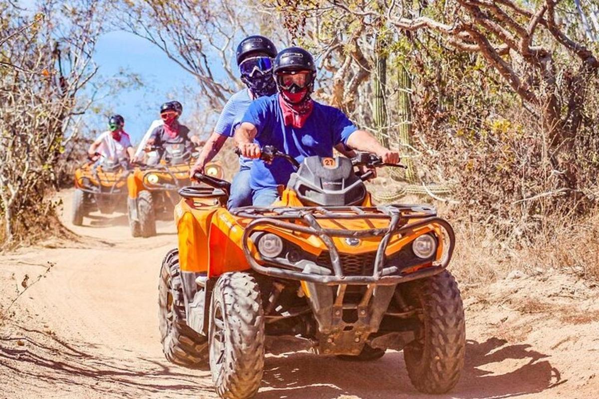 un grup de persones que viatgen en un quad per un camí de terra