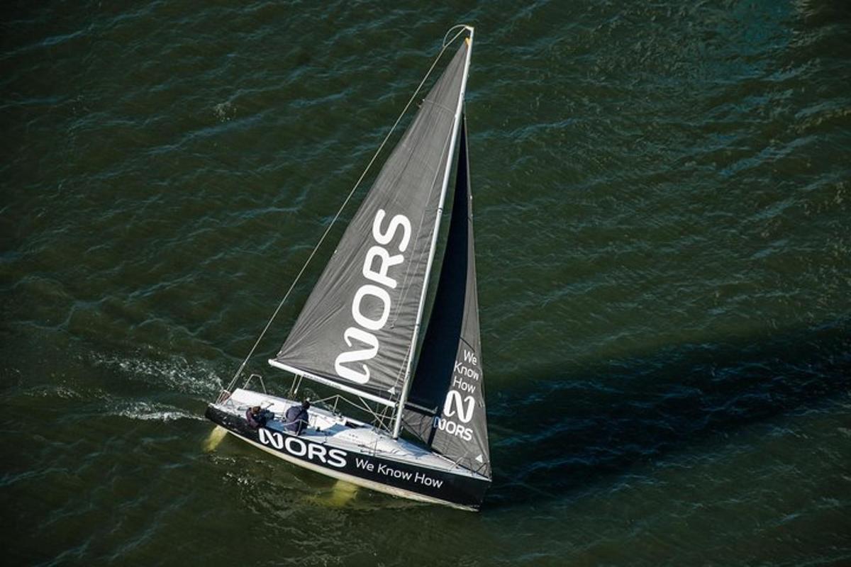 um pequeno barco à vela preto na água