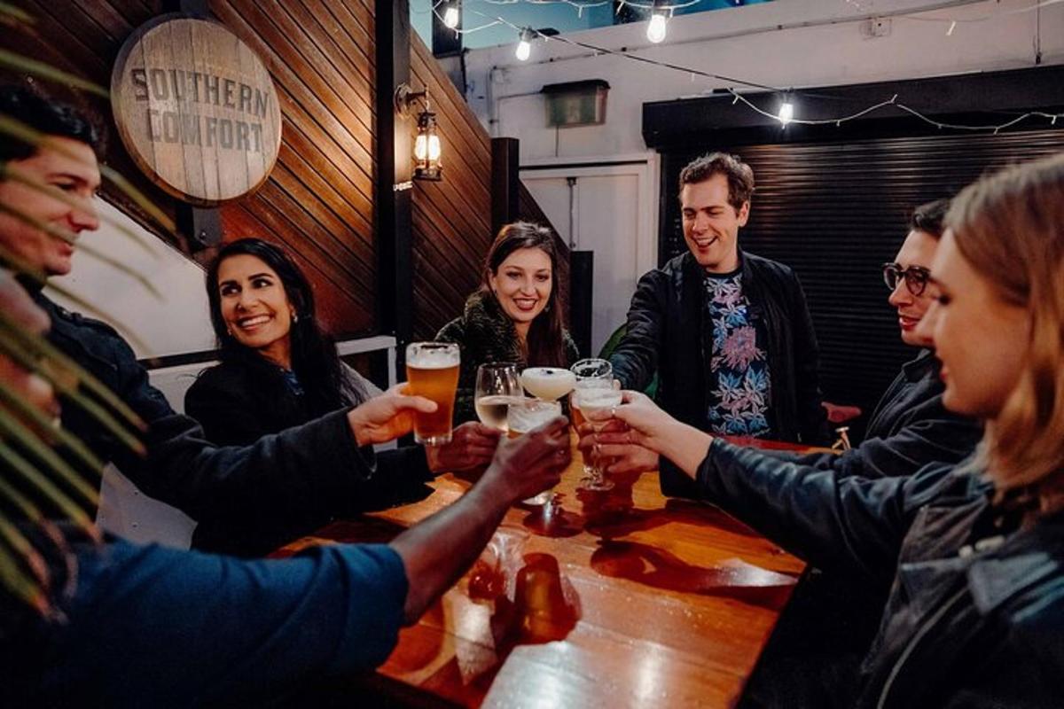 un gruppo di persone sedute attorno a un tavolo a bere birra