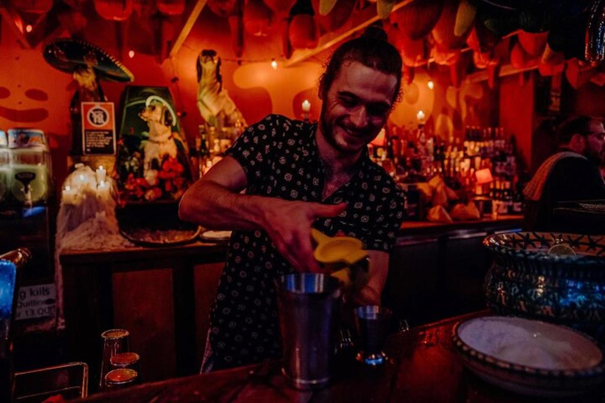 un uomo in piedi in un bar che prepara un drink
