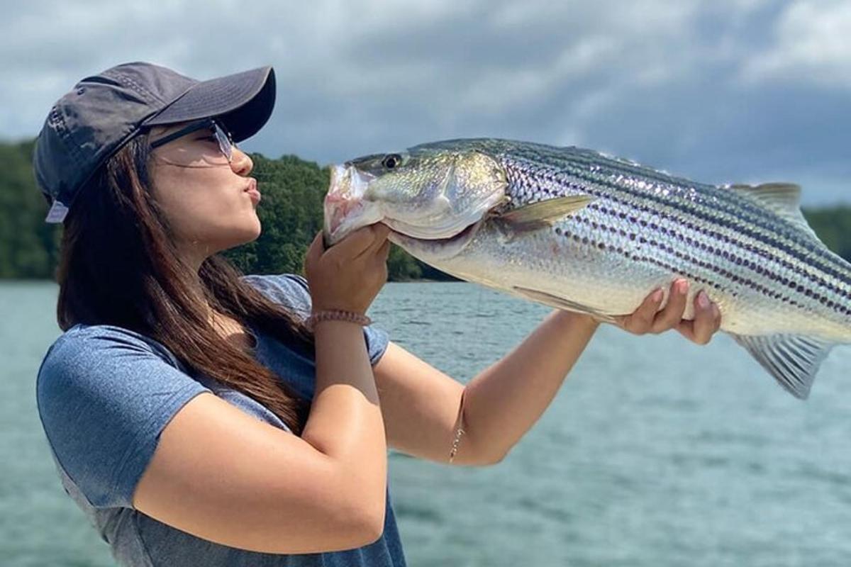 uma mulher segurando um peixe na boca
