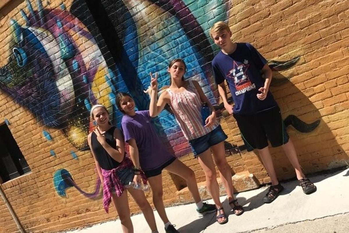 a group of people standing in front of a wall