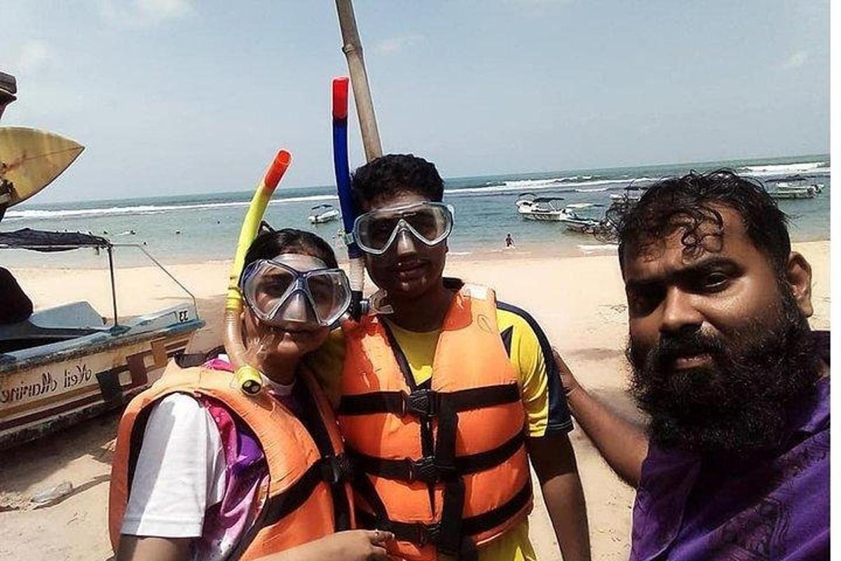 en gruppe på tre personer som står på stranden