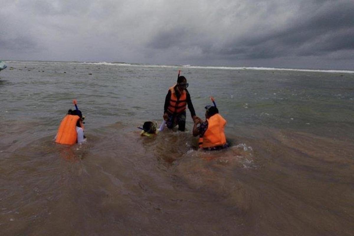 en gruppe mennesker i vannet på stranden