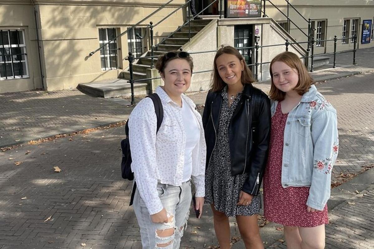 tres dones posant per a una foto davant d'un edifici