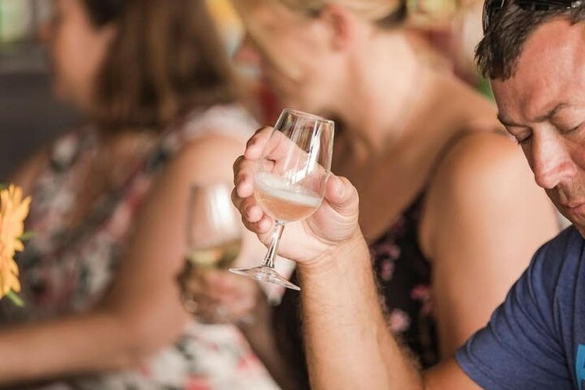 a man holding a glass of white wine