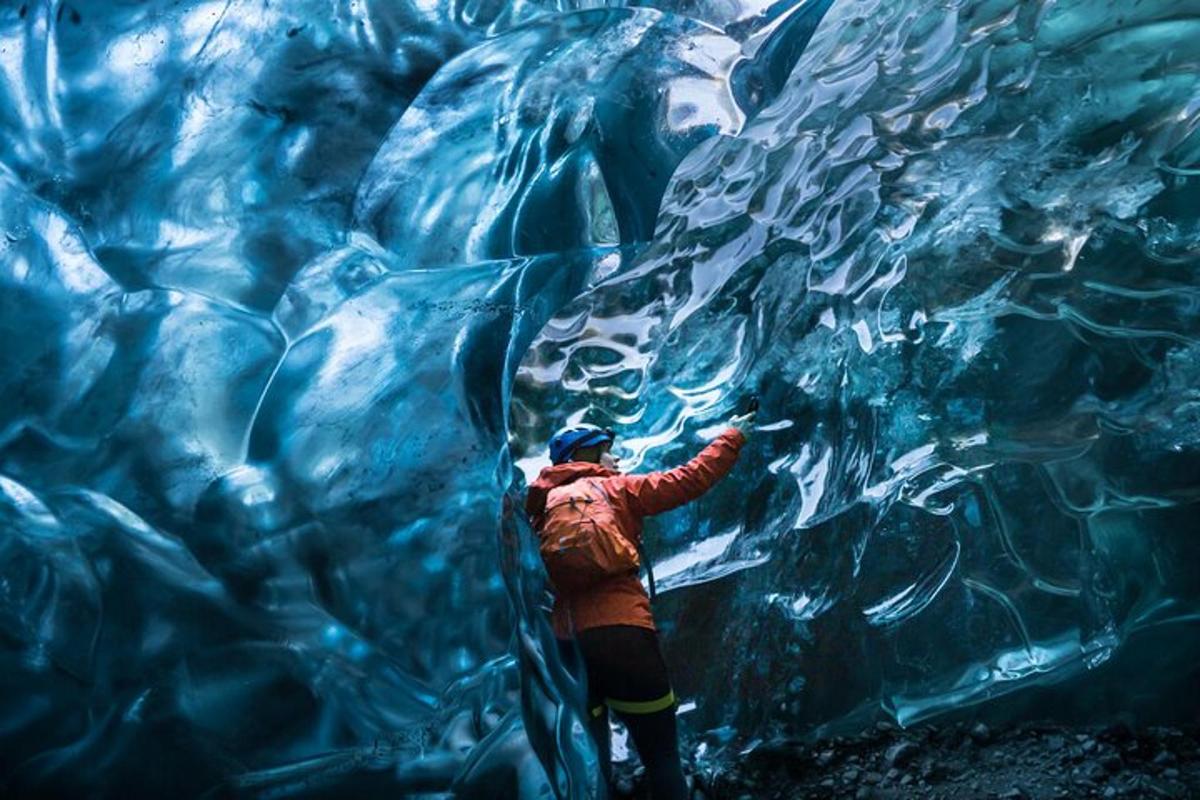 uma pessoa está parada em frente a uma caverna de gelo
