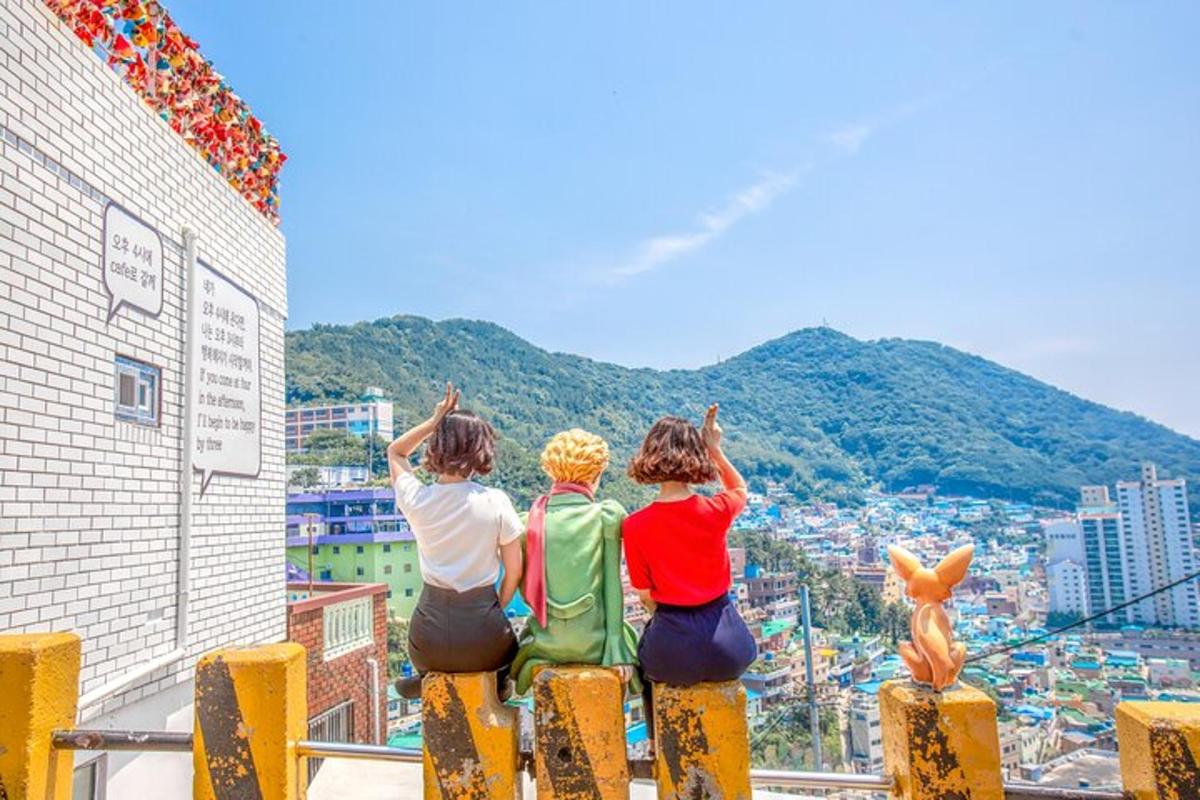 건물 꼭대기에 앉아 도시를 바라보는 세 사람