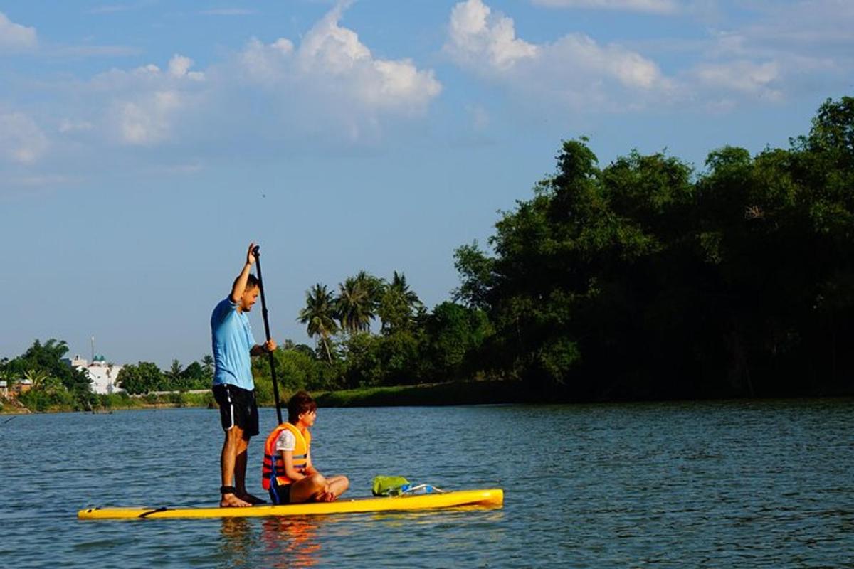 dua lelaki di atas papan dayung di dalam air