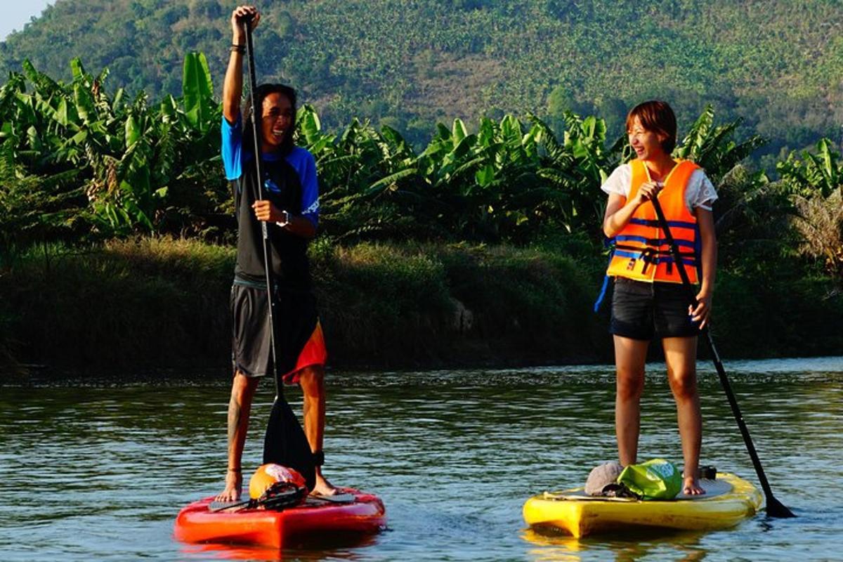 dva lidé stojí na paddleboardech ve vodě