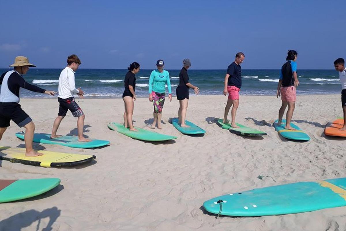 a group of people standing on surfboards on the beach