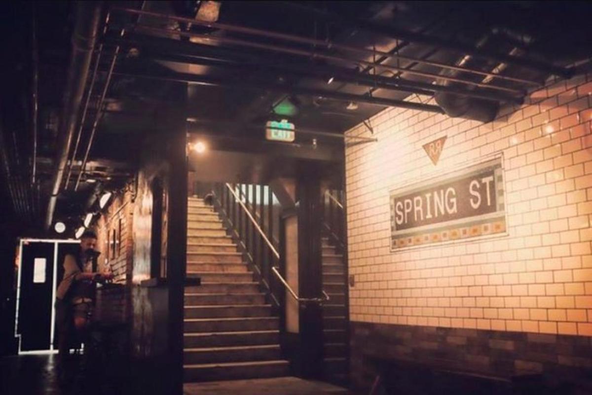 a building with stairs and a sign that reads spring st