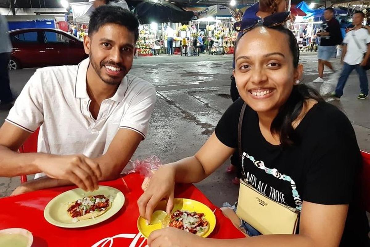 um homem e uma mulher sentados à mesa com um prato de comida