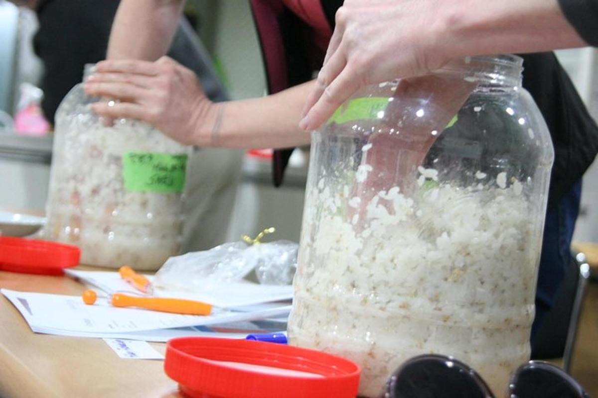 a person standing next to a jar of rice