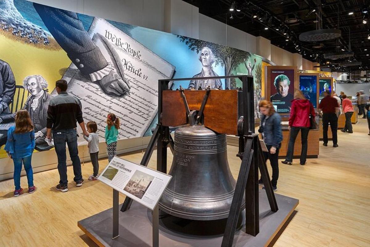 a group of children looking at a liberty bell in a museum