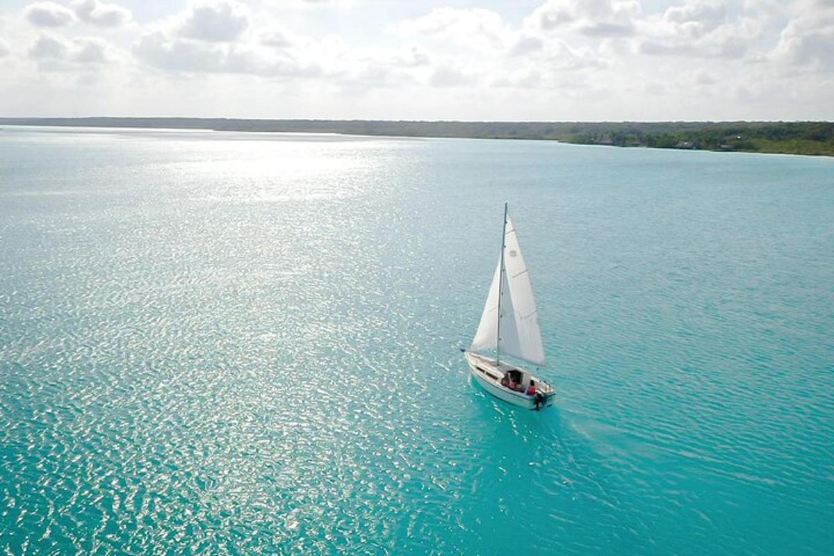 a small sail boat in the middle of the water