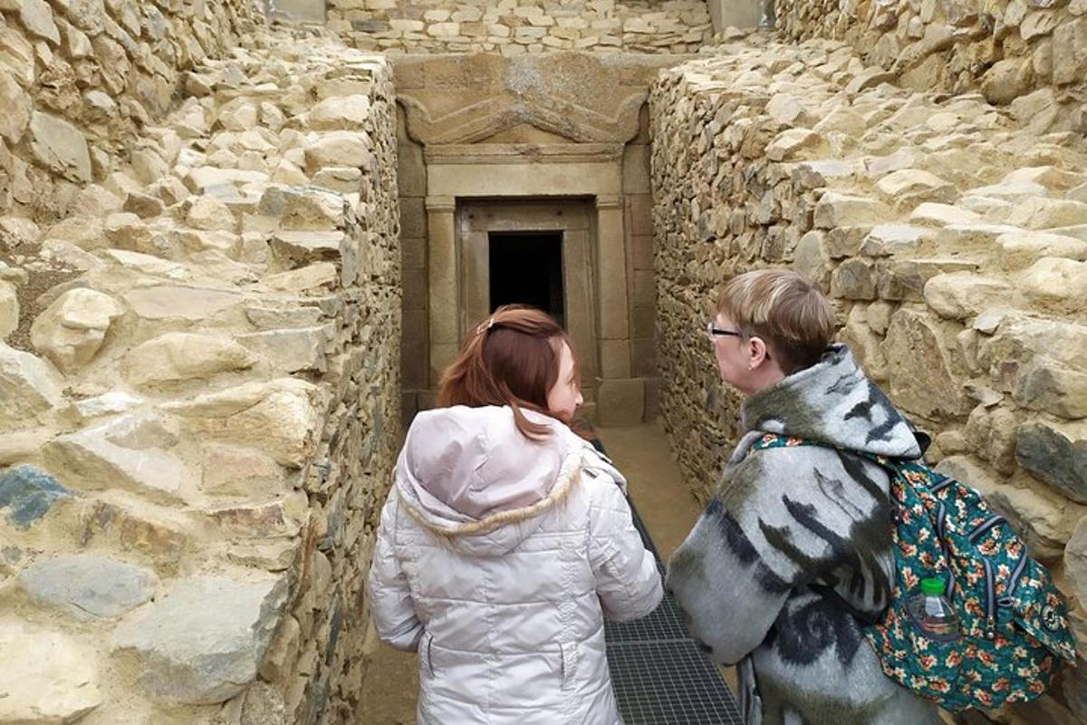 a man and a woman looking at a stone wall