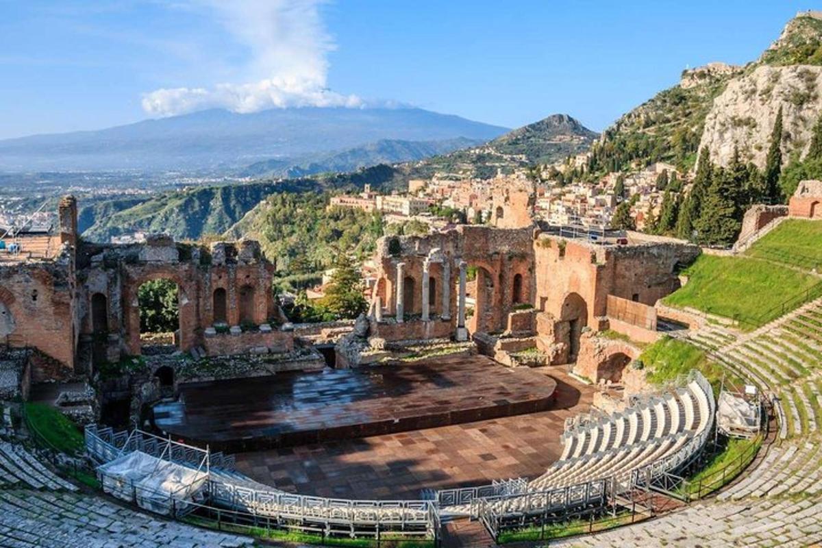 an ancient amphitheater with a mountain in the background