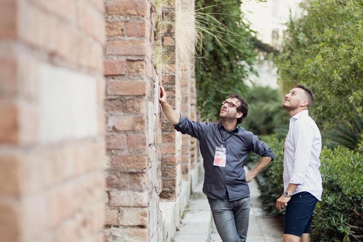 two men are looking up at a brick wall