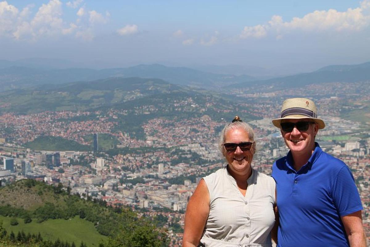 a man and a woman standing on top of a mountain